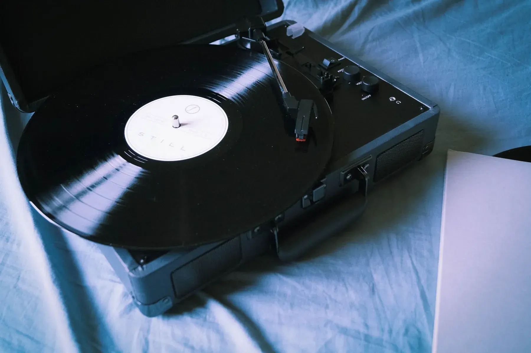 A record on a turntable, on a blue sheet.